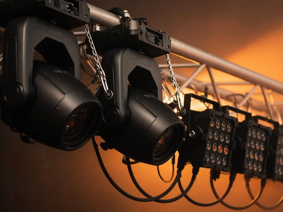 Cabezas móviles y focos LED PAR en truss con cableado DMX para iluminación escénica